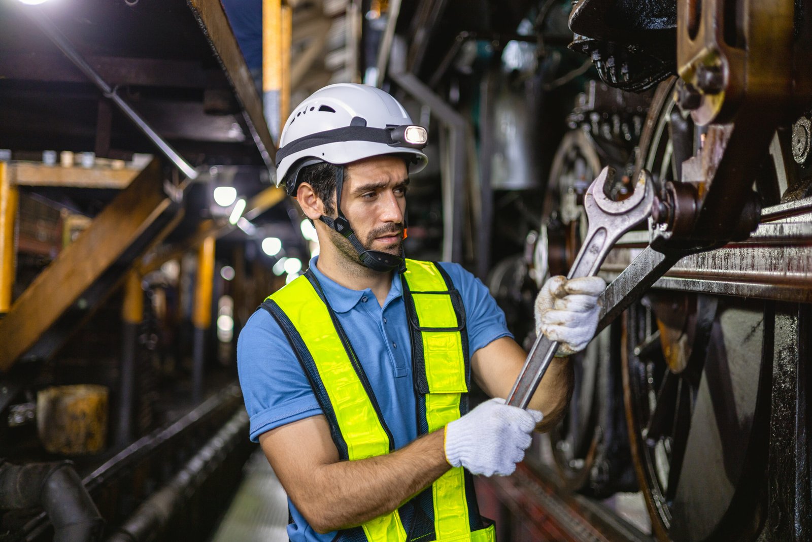 worker working in industrial factory uses a cross screwdriver to inspect the machine.